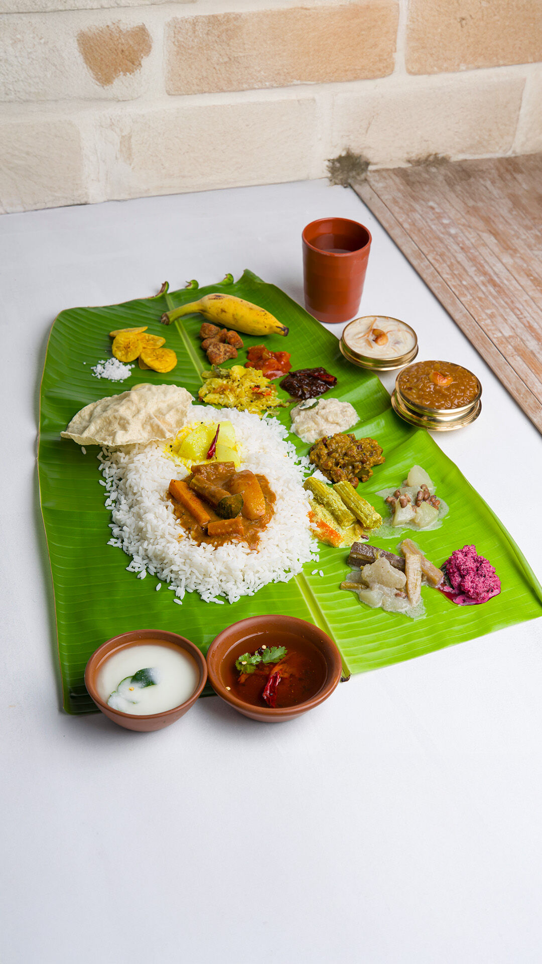 Traditional Onam Sadhya meal served on a banana leaf featuring Kerala dishes like avial, sambar, rice, banana chips, pickles, payasam, and papadam, symbolizing the festive spirit of Onam.